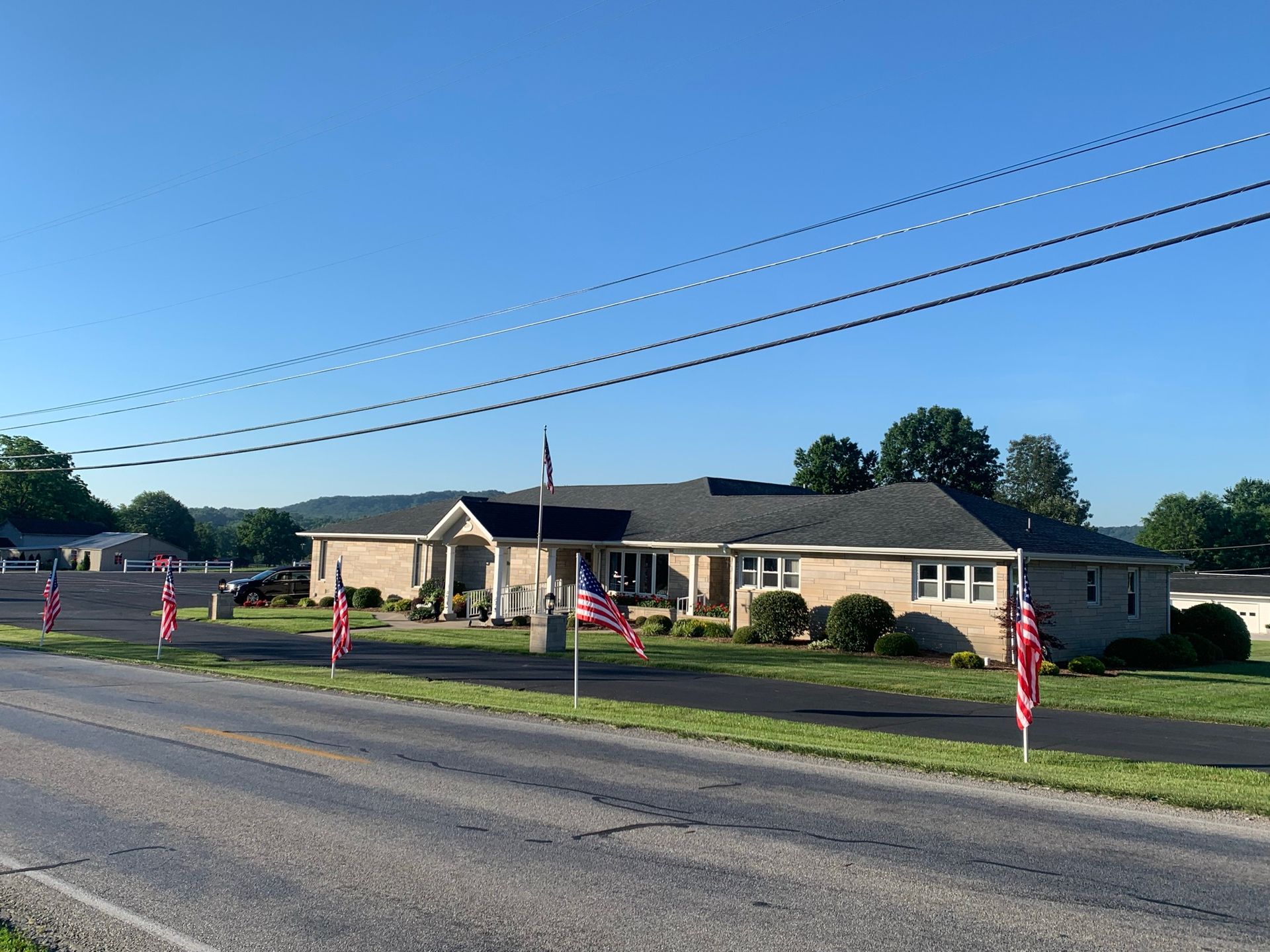 A large white house with a handicapped parking spot in front of it.