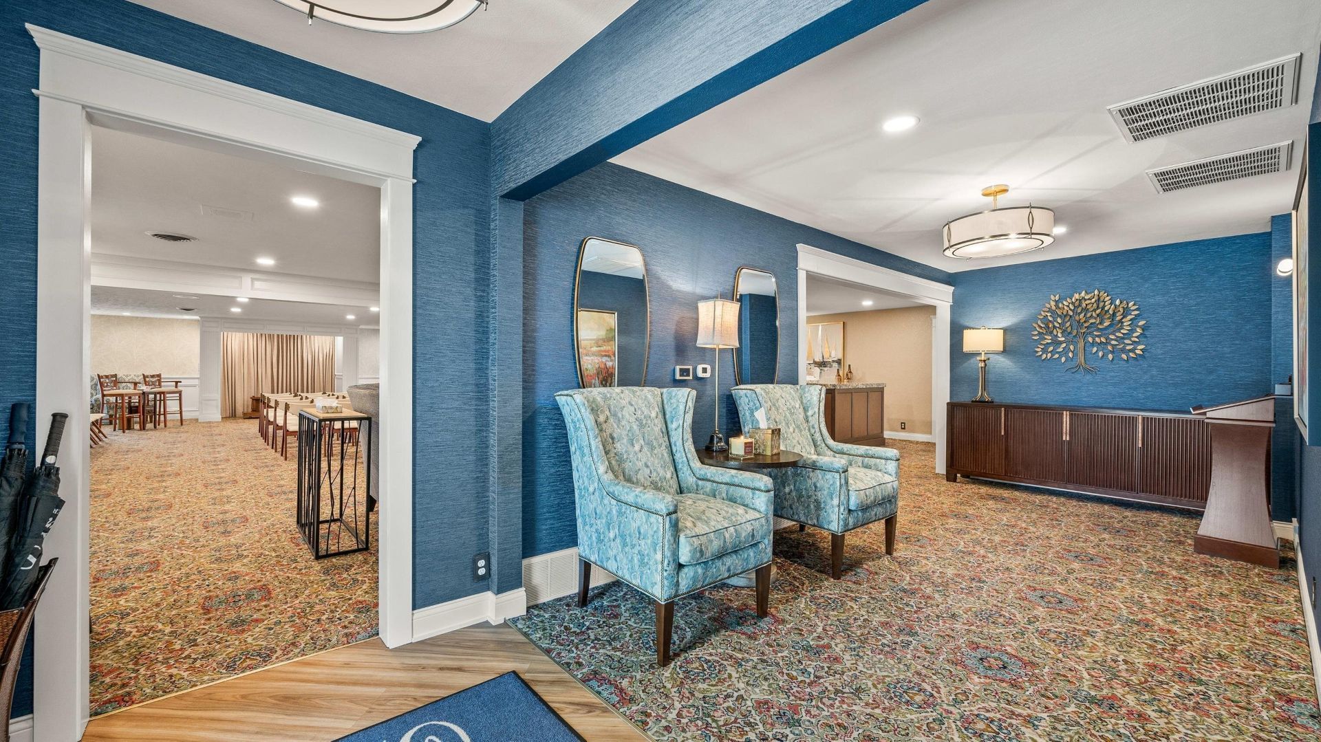 A brick building with a lot of windows is sitting on the side of the road.