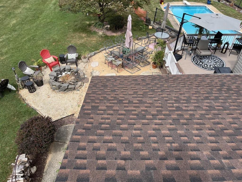 An aerial view of a backyard with a fire pit and a pool.
