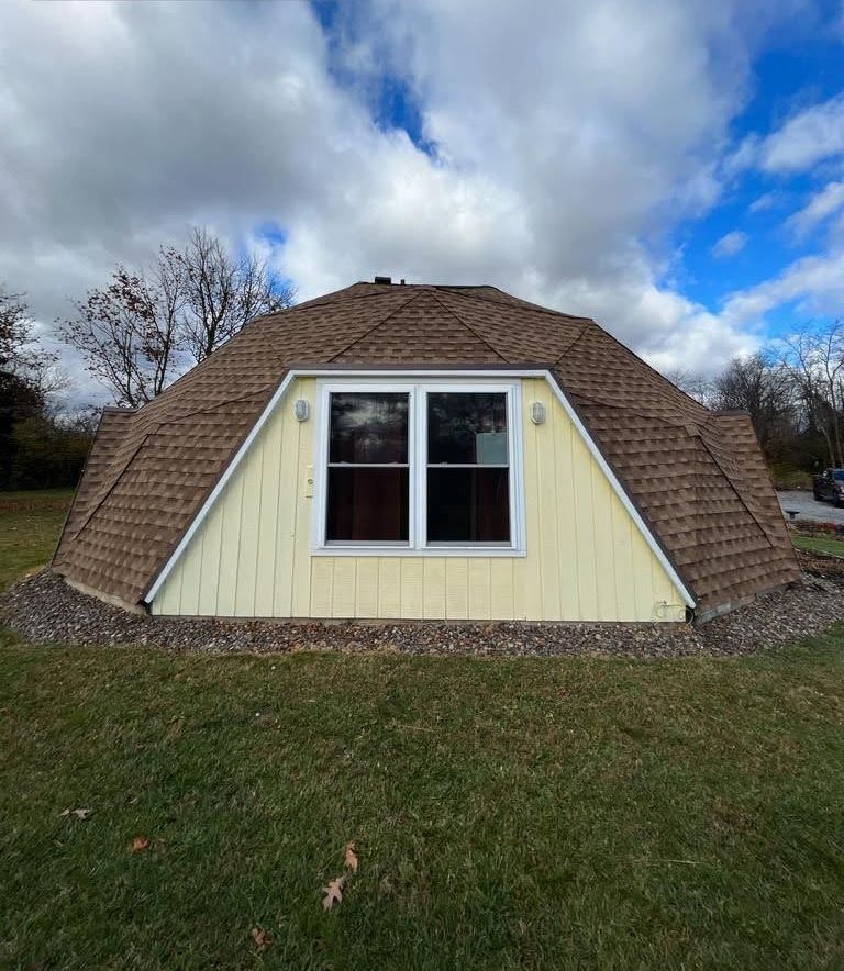 A dome shaped house with a roof and a window