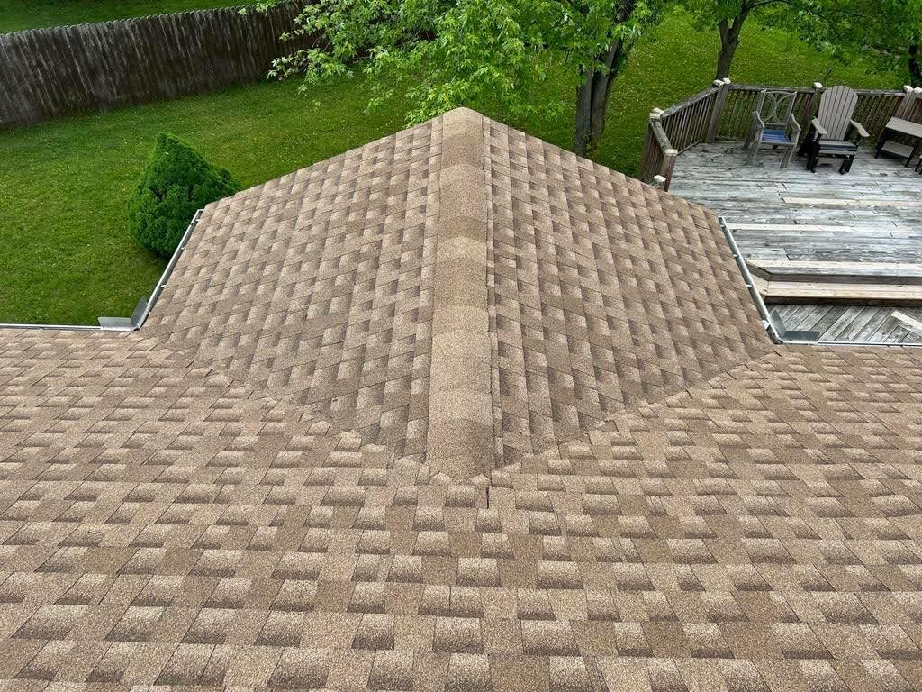 The roof of a house with a deck in the background.