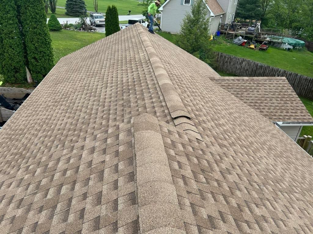 A man is standing on the roof of a house.