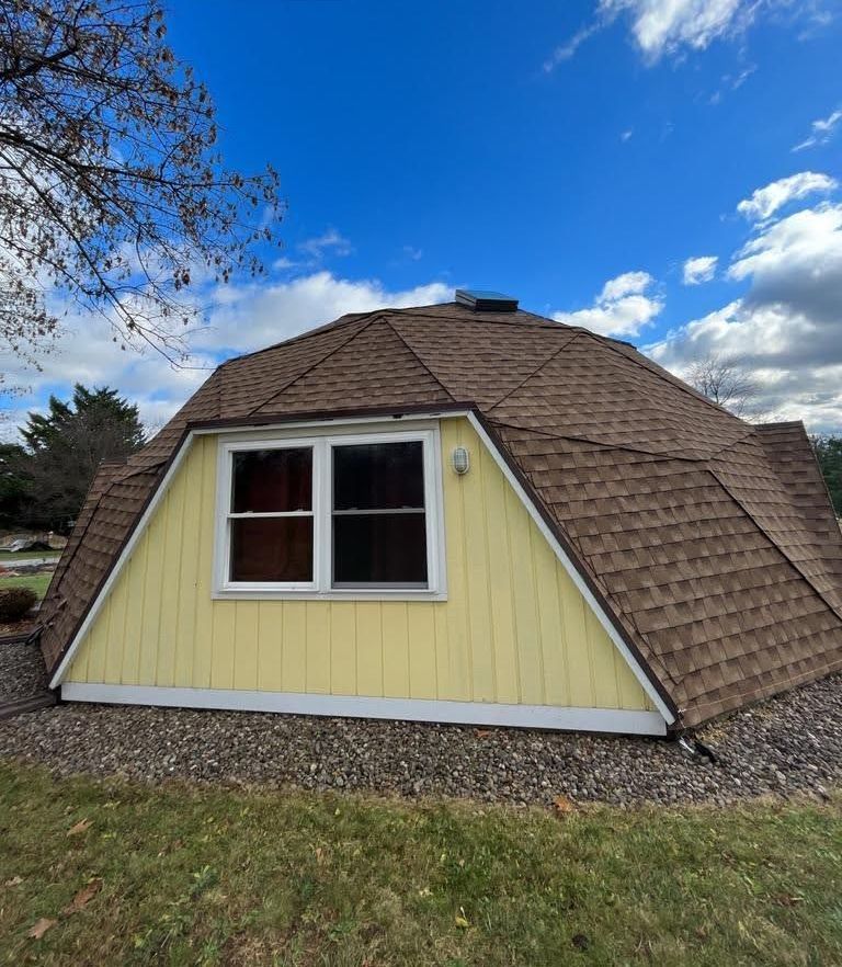 A dome shaped house with a brown roof
