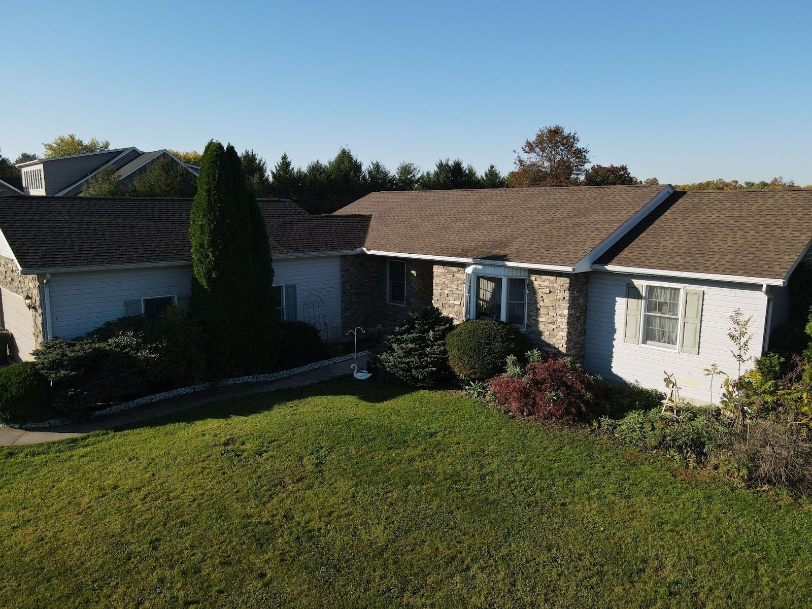 An aerial view of a house with a large lawn in front of it