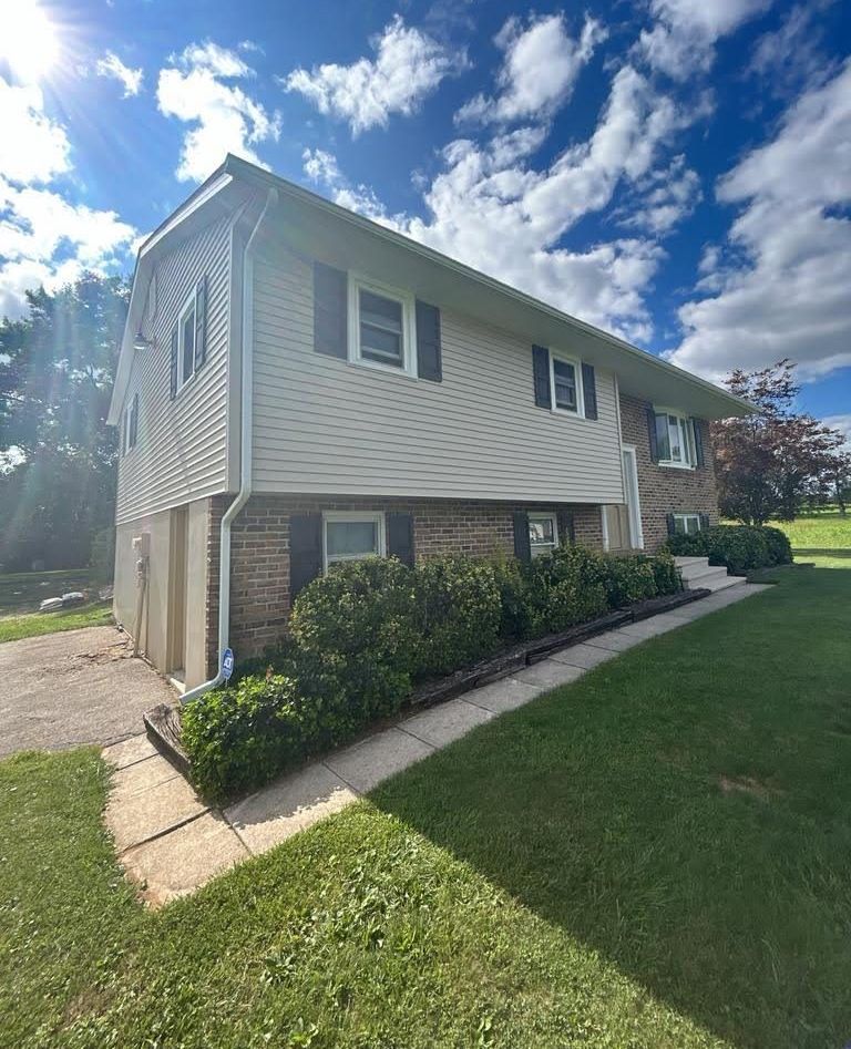 A house with a lot of windows and a lot of grass in front of it.