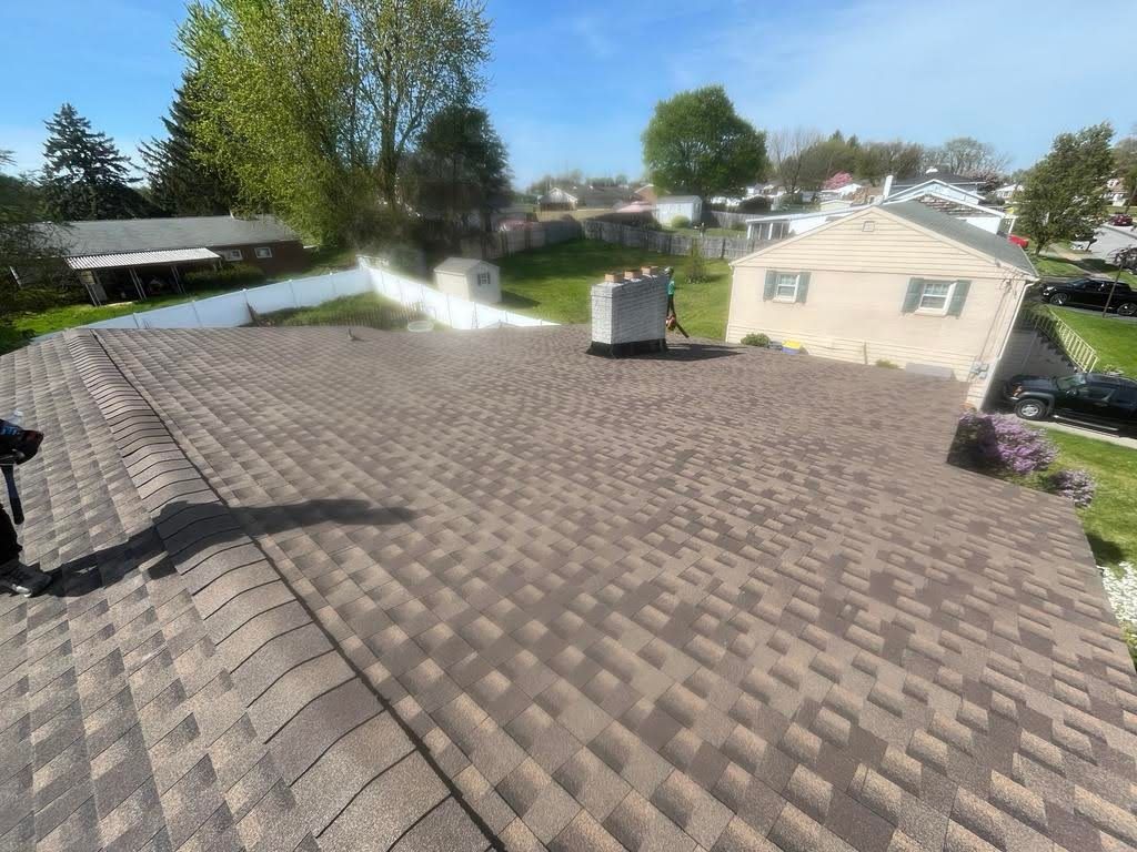 A person is standing on the roof of a house.