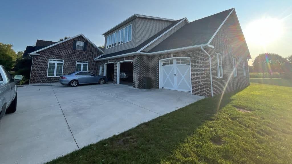 A large brick house with a car parked in front of it.