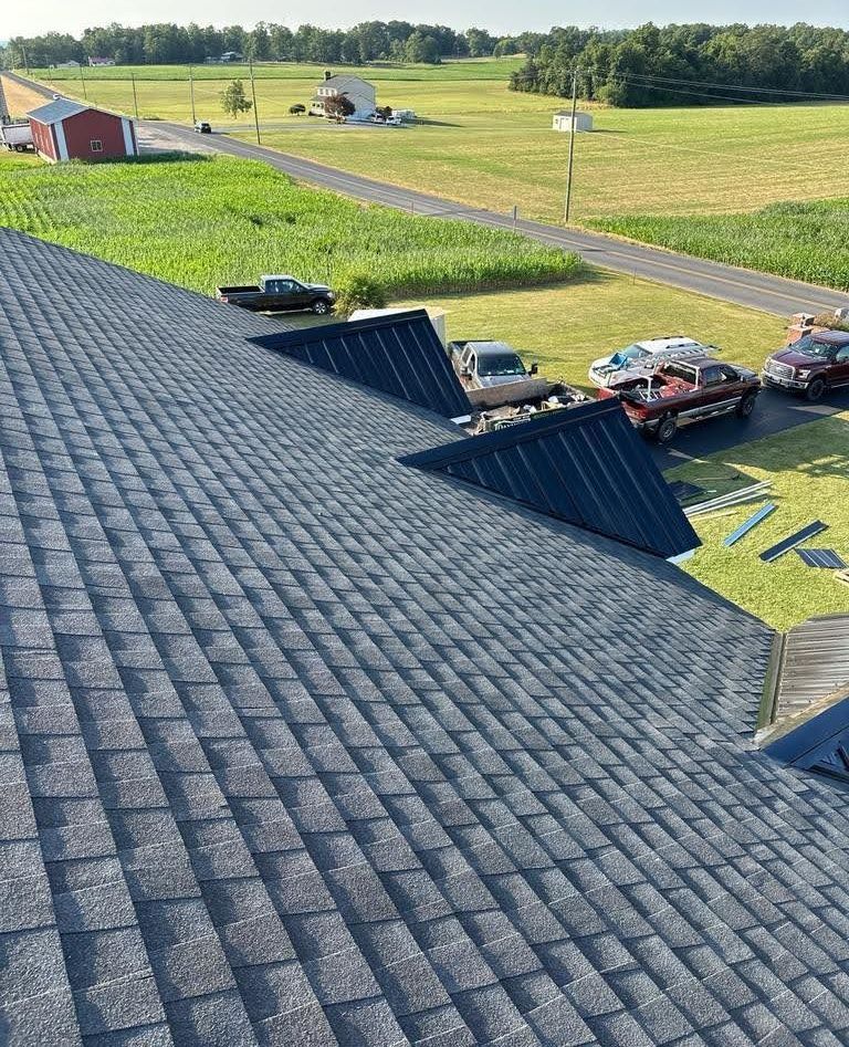 A roof with a lot of cars parked on it and a field in the background.
