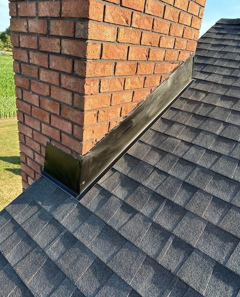 A close up of a brick chimney on top of a roof.