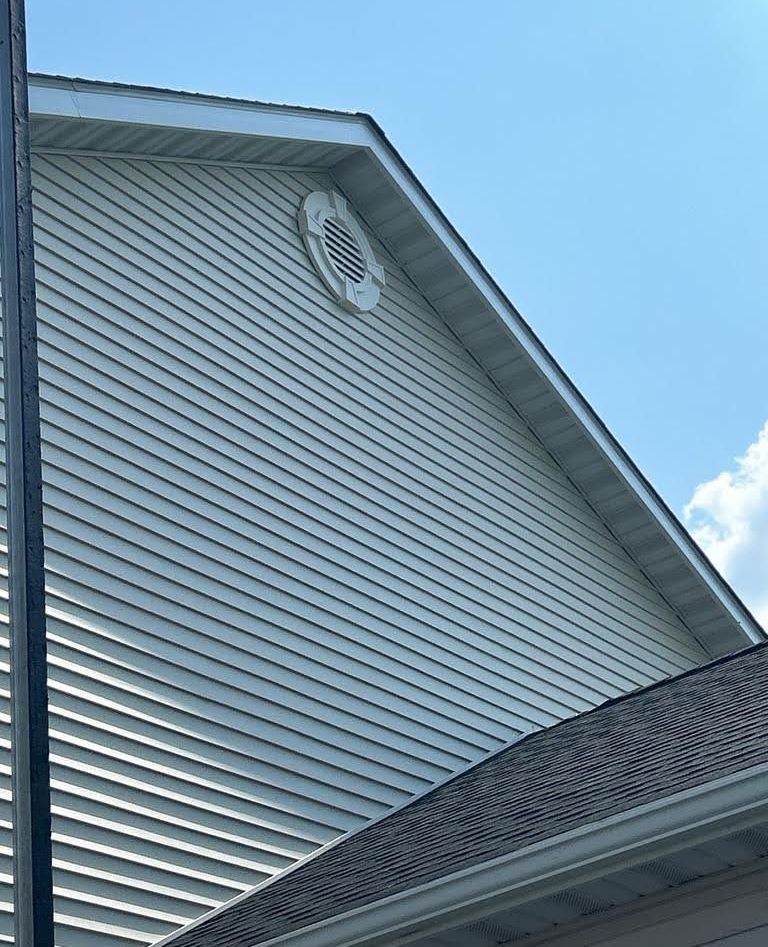 A white house with a roof and a chimney on it.