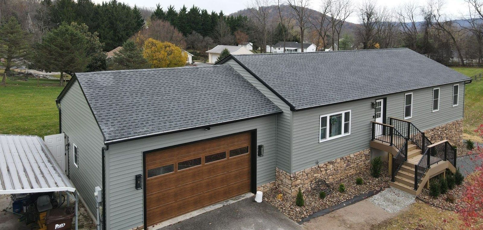 An aerial view of a house with a garage and a carport.