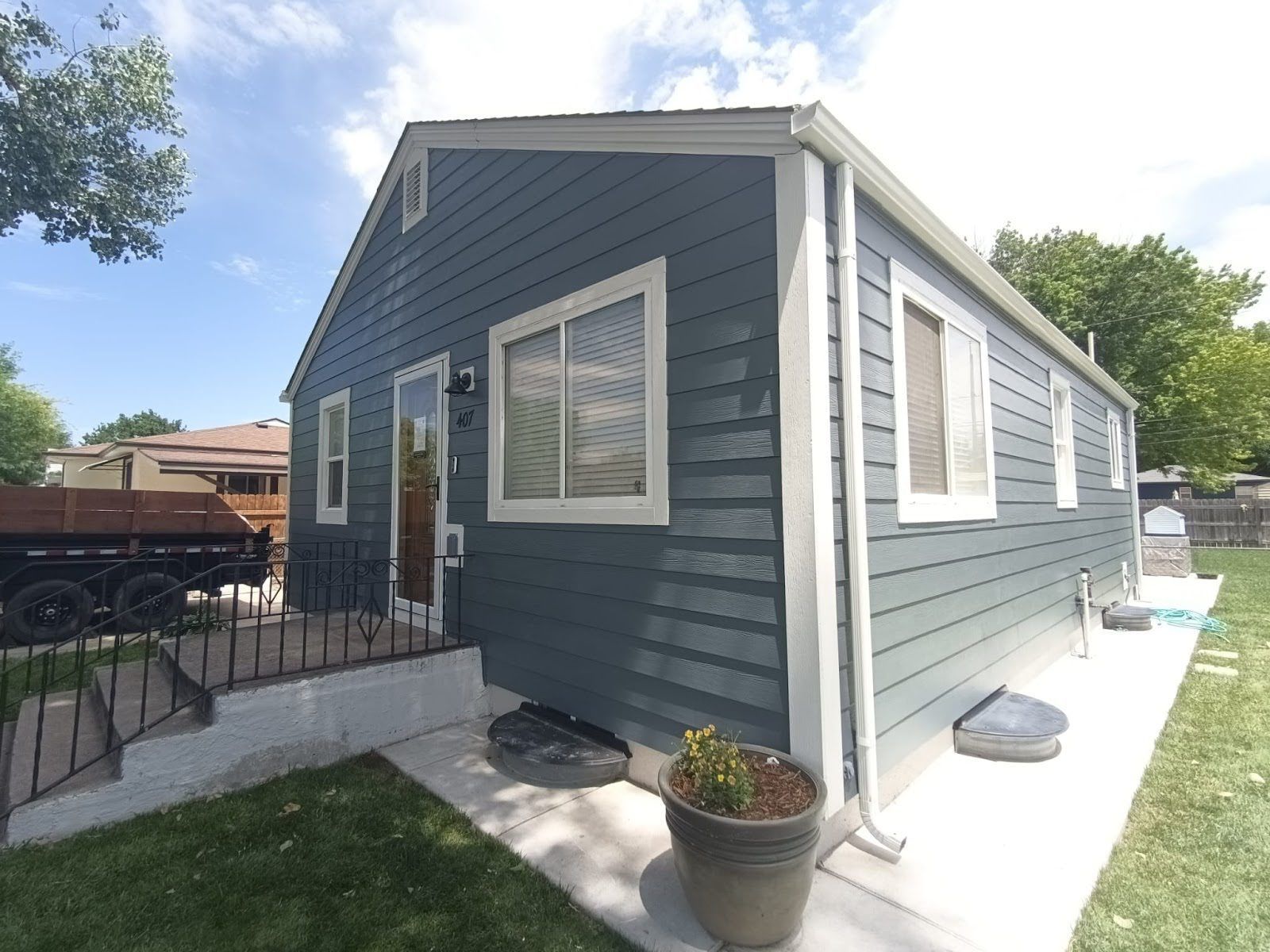 A small house with a blue siding and white trim