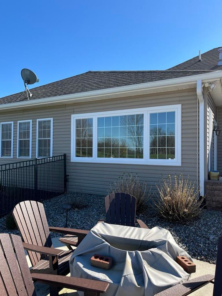 A house with a fire pit and chairs in front of it