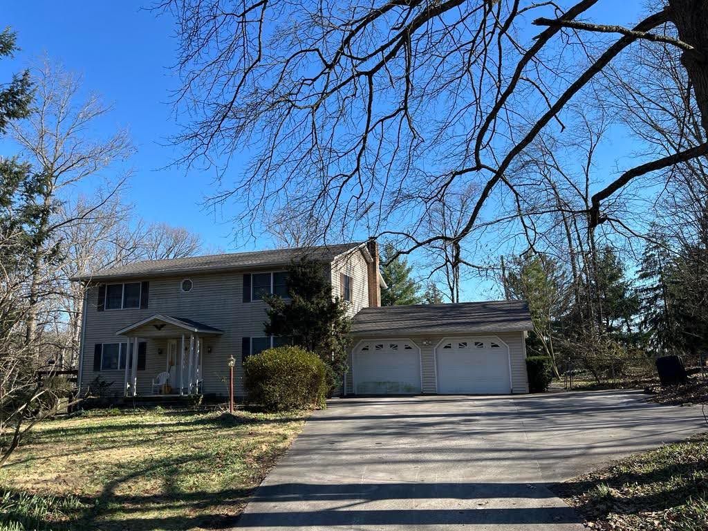 A house with a garage and a driveway in front of it.