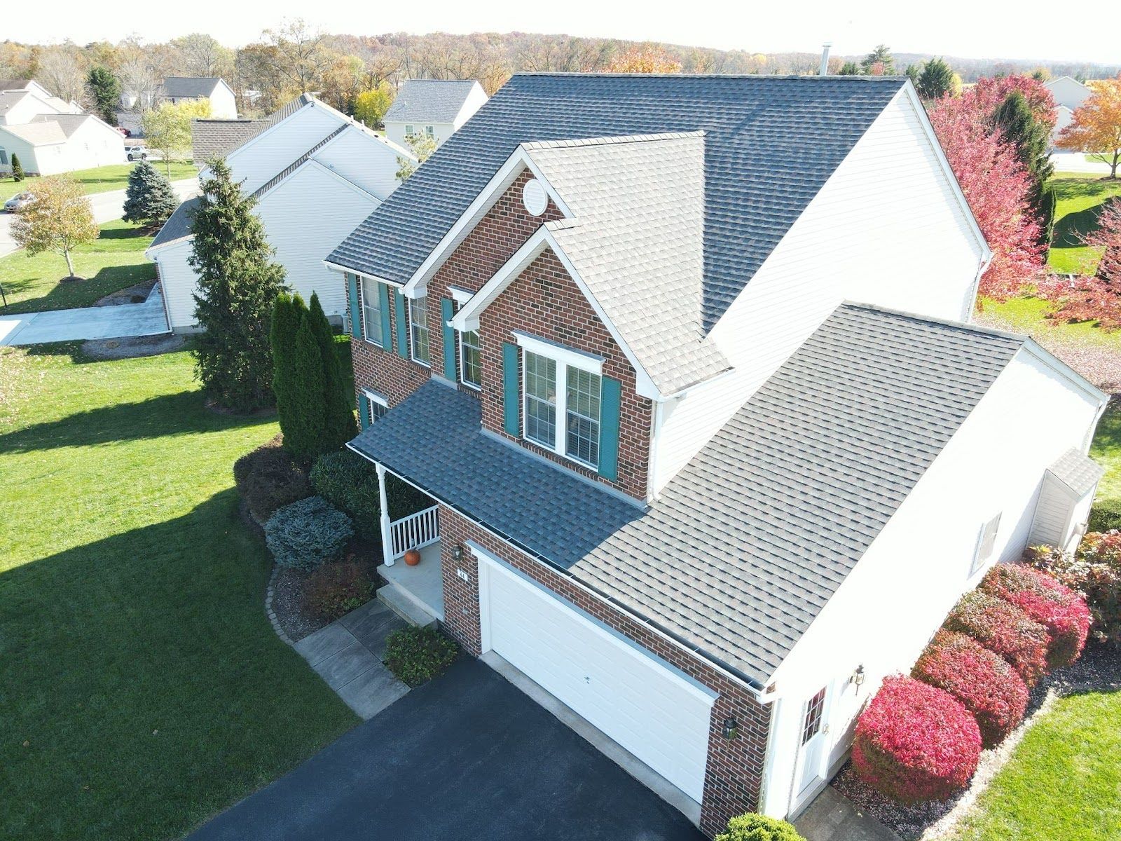 An aerial view of a brick house with a blue roof