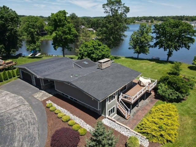 An aerial view of a house with a lake in the background