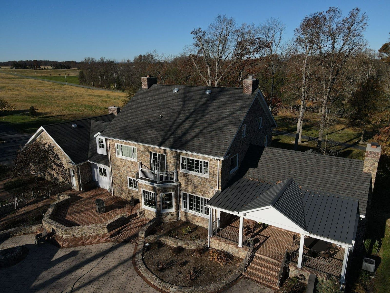 An aerial view of a large house with a gray roof