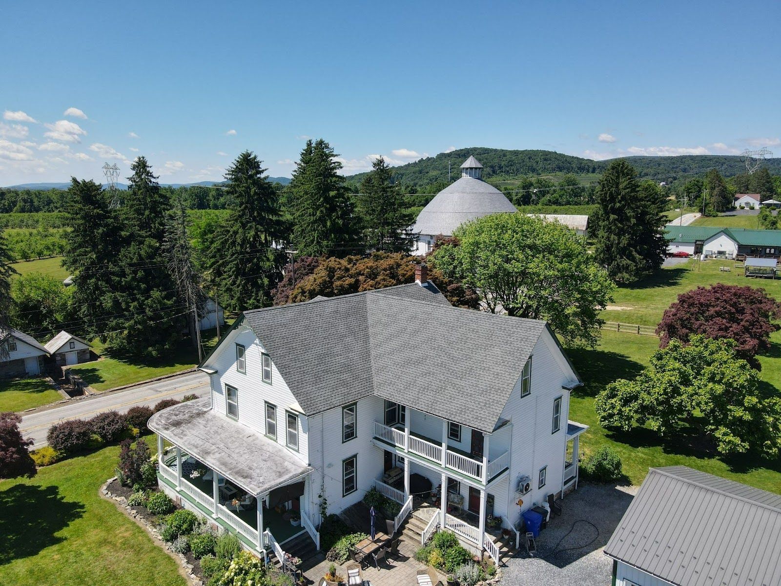 An aerial view of a large white house surrounded by trees and grass.