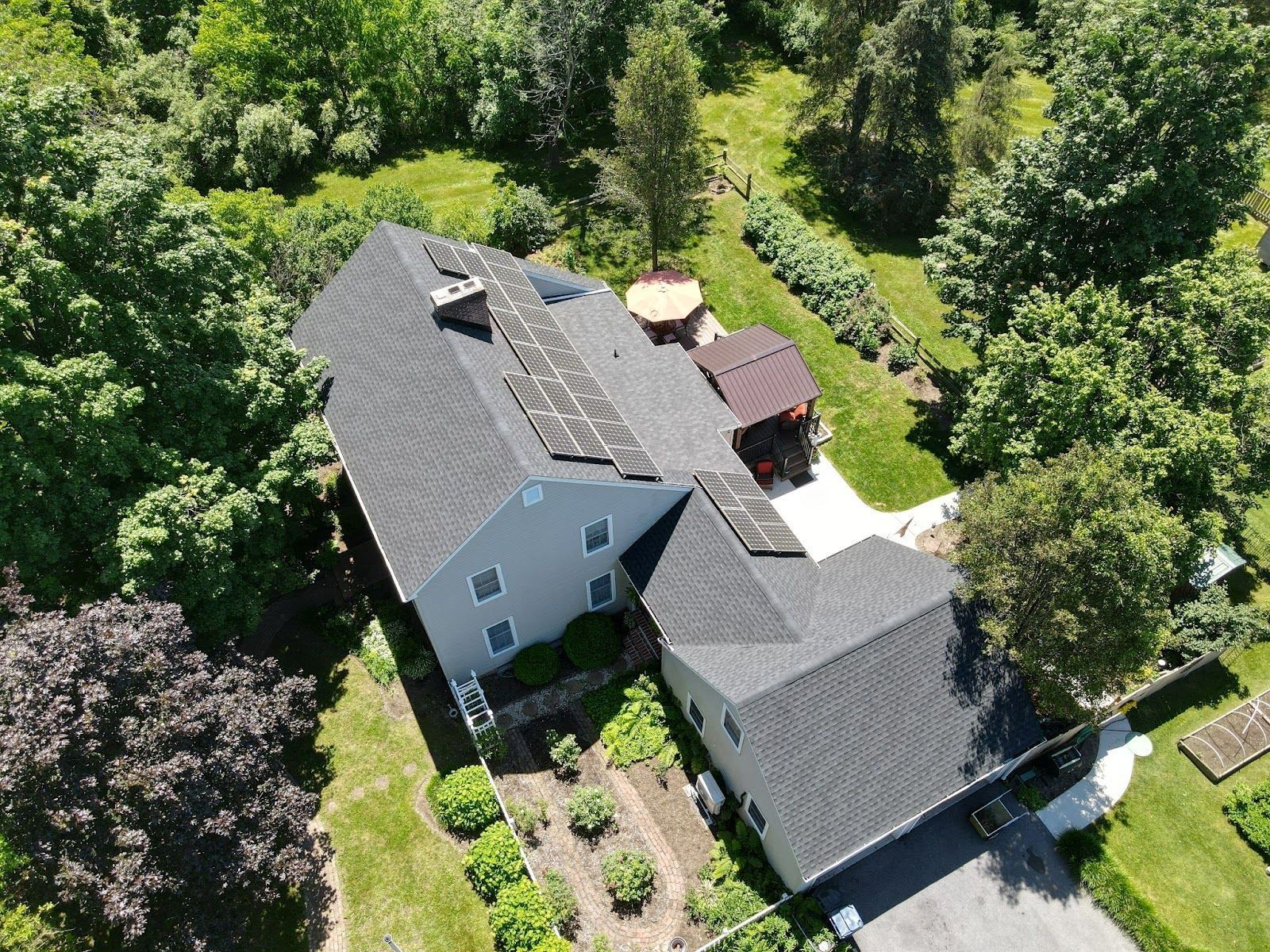 An aerial view of a house with solar panels on the roof