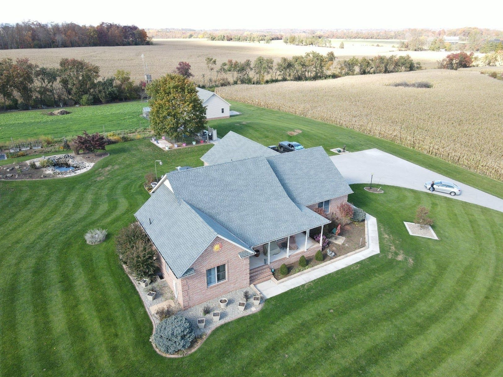 An aerial view of a house in the middle of a lush green field.