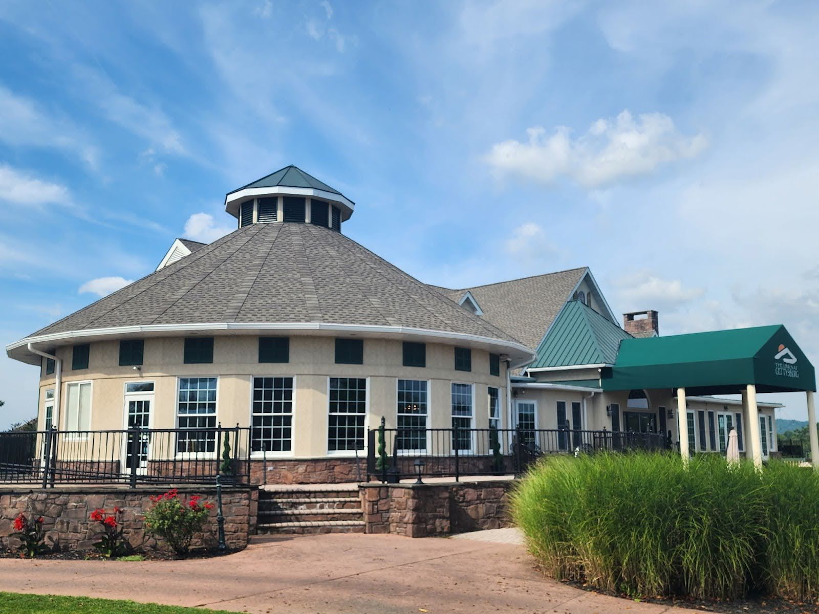 A large round building with a green awning on the side of it.