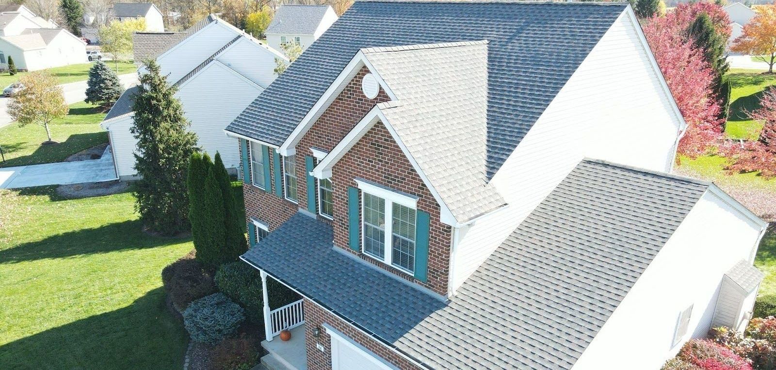 An aerial view of a house with a new roof in a residential area.