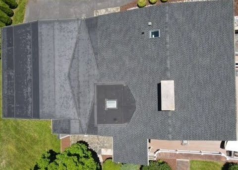 An aerial view of a roof of a house with a skylight.