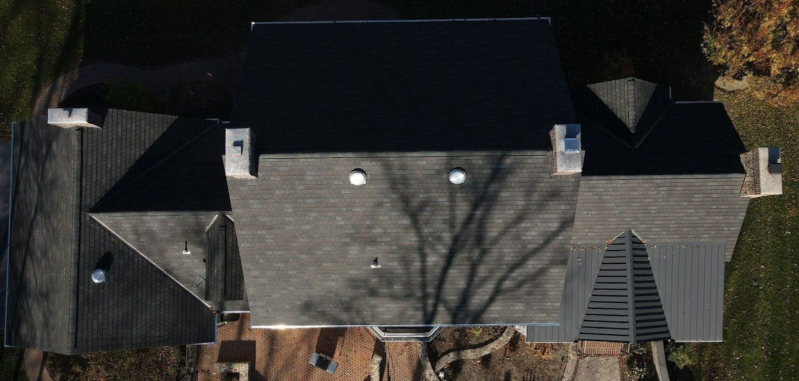 An aerial view of a house with a black roof