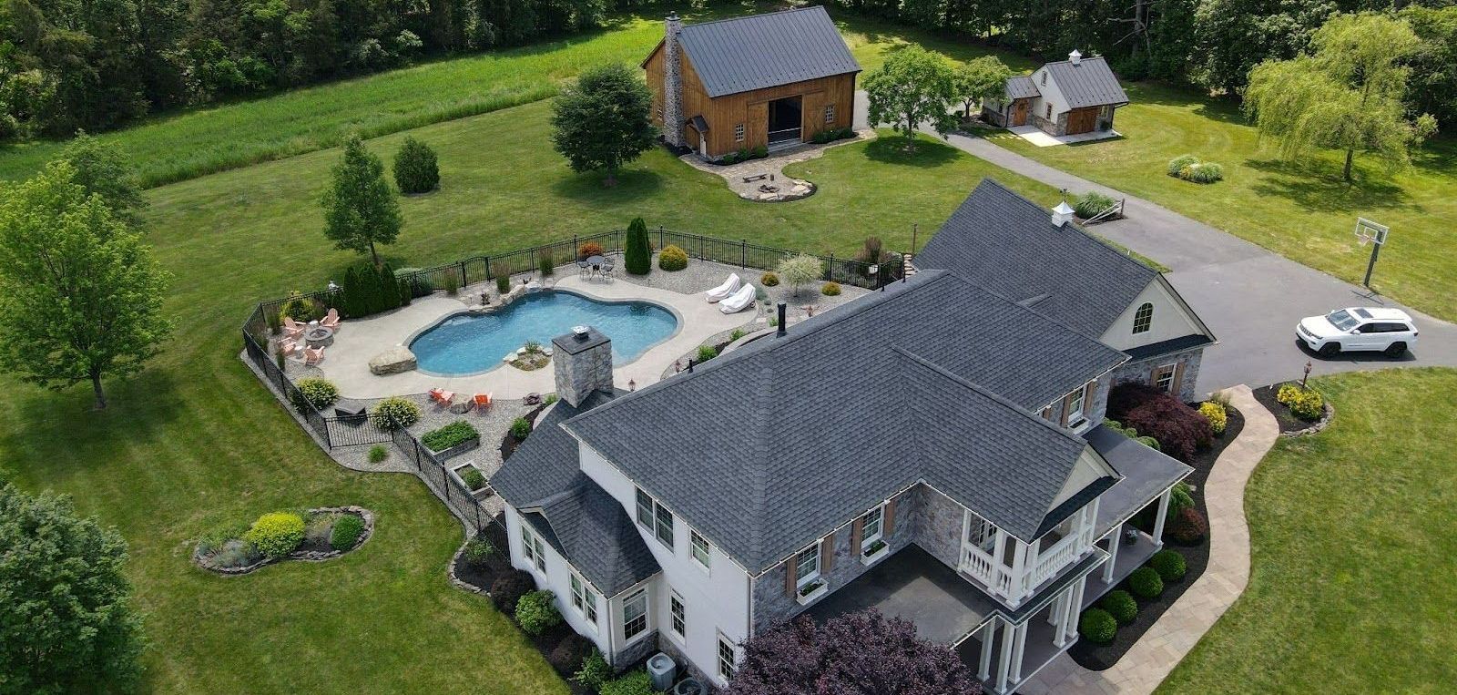 An aerial view of a large house with a pool in the backyard.