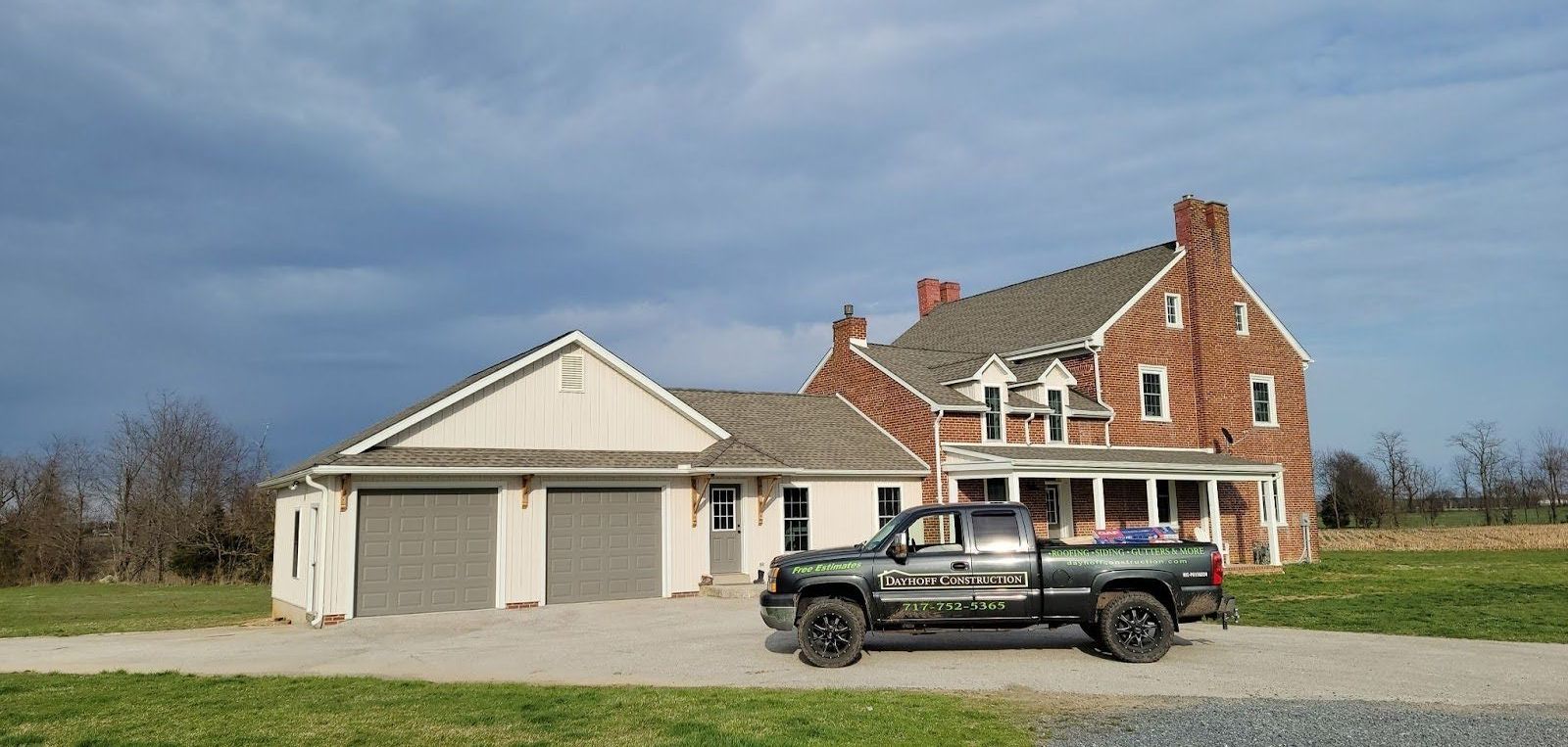 A truck is parked in front of a large brick house.