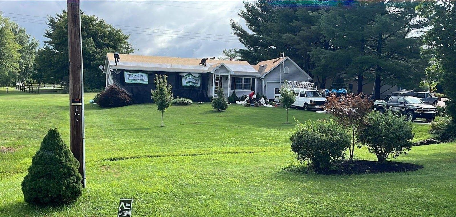 A house is sitting in the middle of a lush green field.