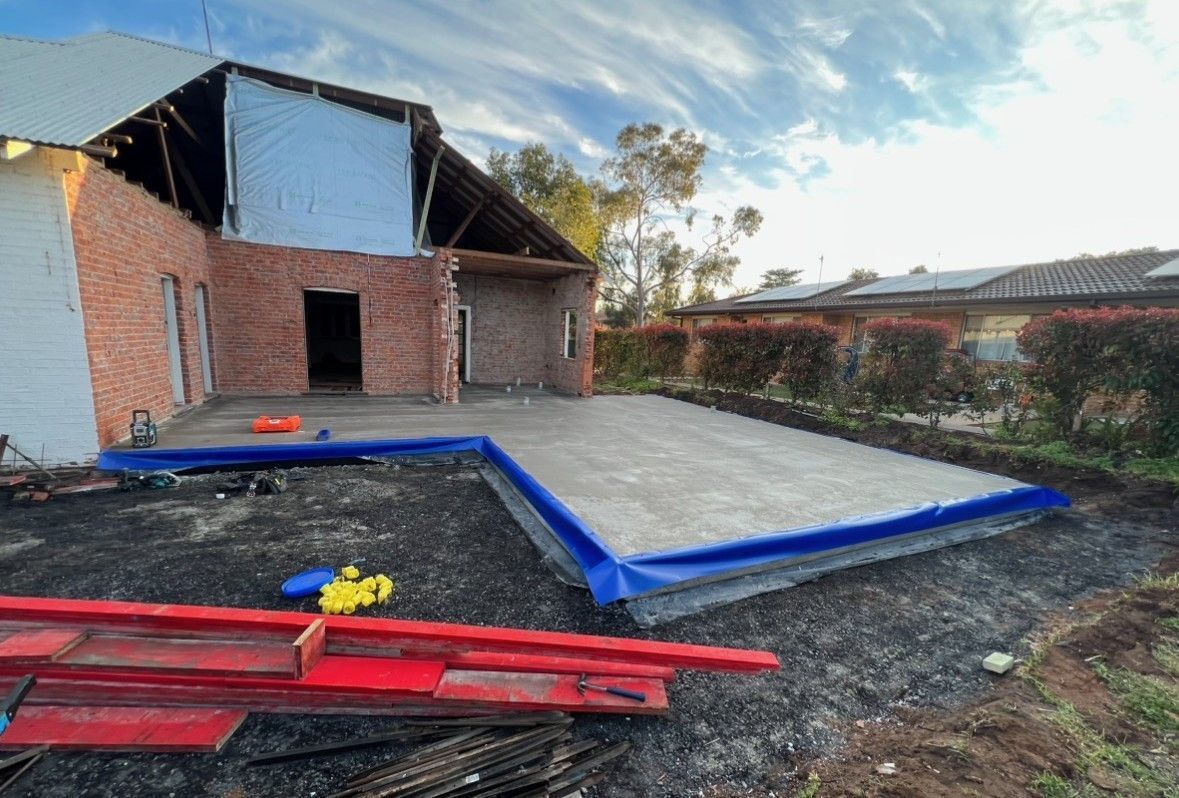 A Person is Holding a Level Over a Piece of Wood — JKD Pest & Carpentry In Wellington, NSW