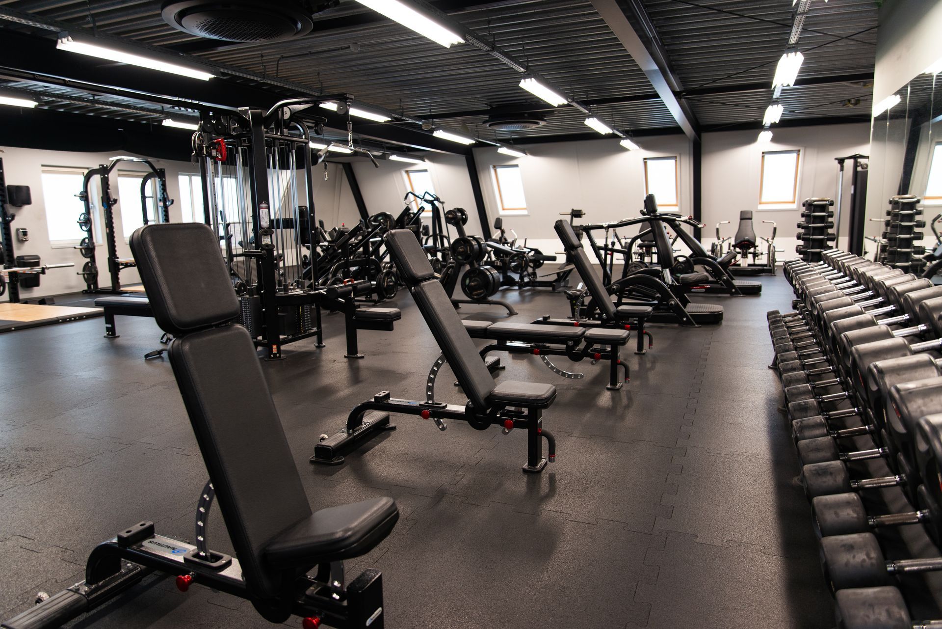 Een grote sportschool met veel banken en halters