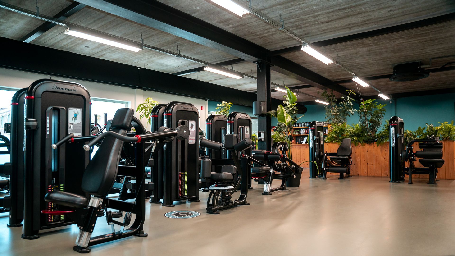 Een grote sportschool met veel banken en halters