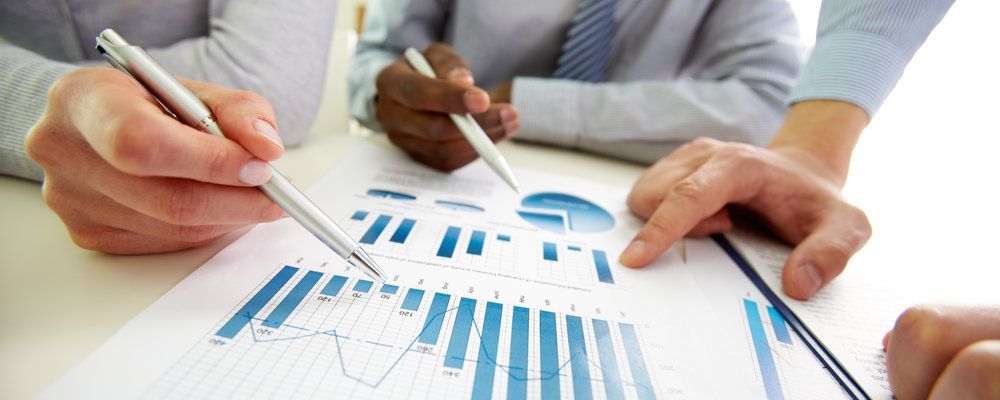 A group of people are sitting at a table looking at a graph.