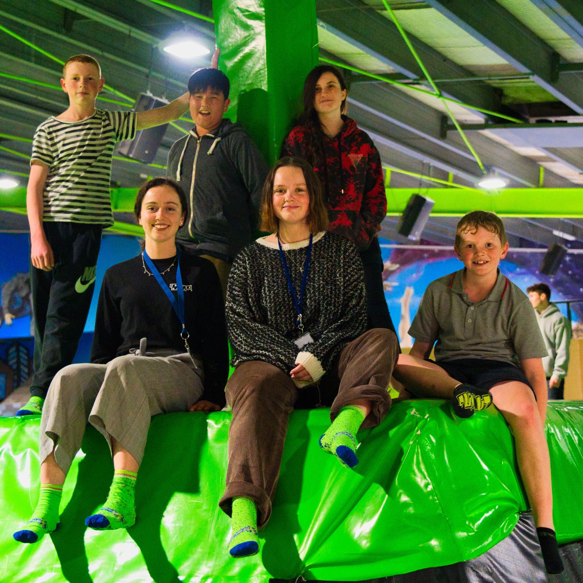 A group of young people sitting in a Trampoline Arena