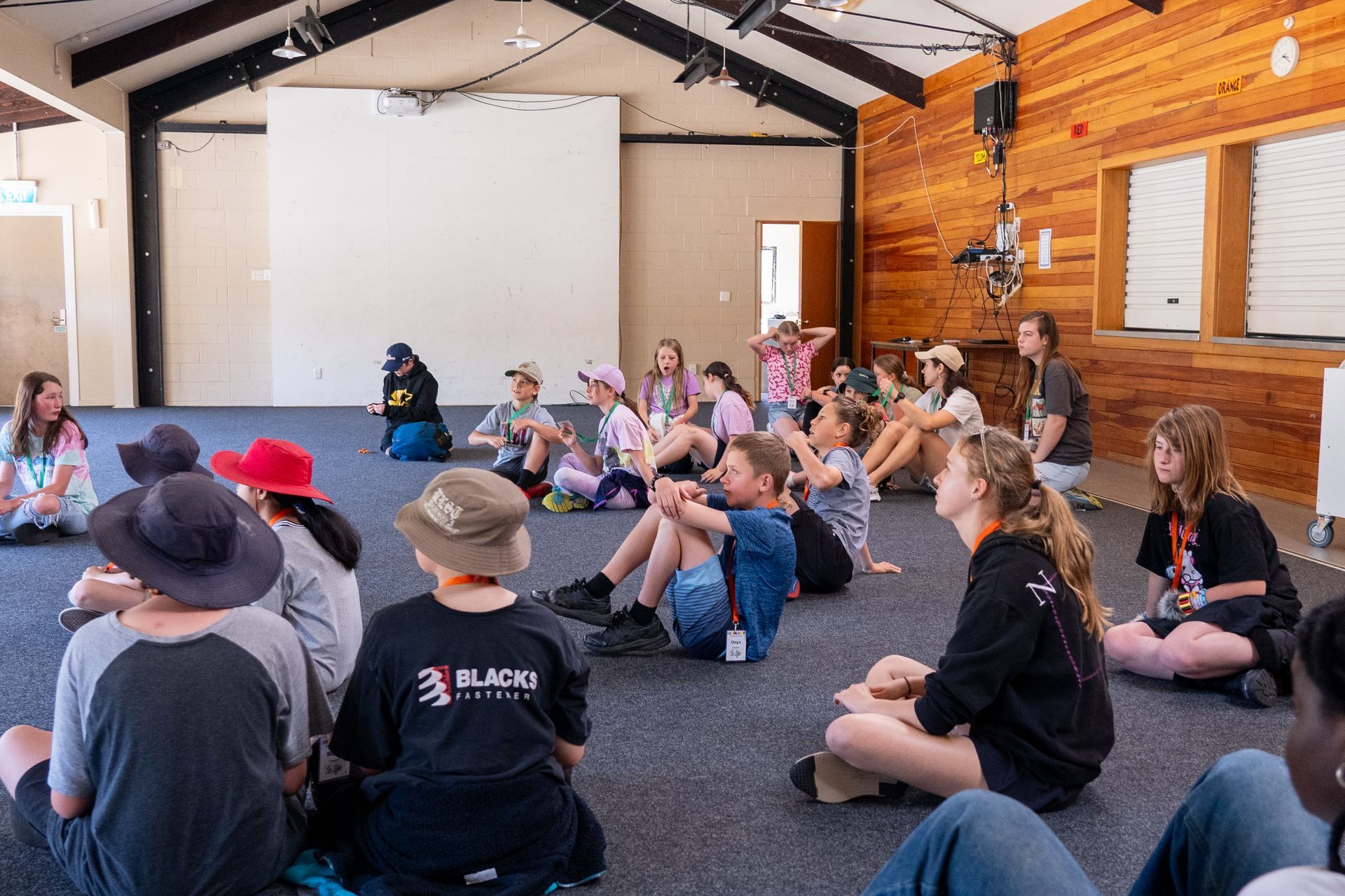 instructions being given to a group of children who are sitting on the floor