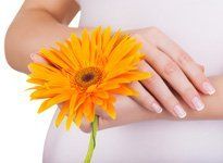 A pregnant woman holding a flower
