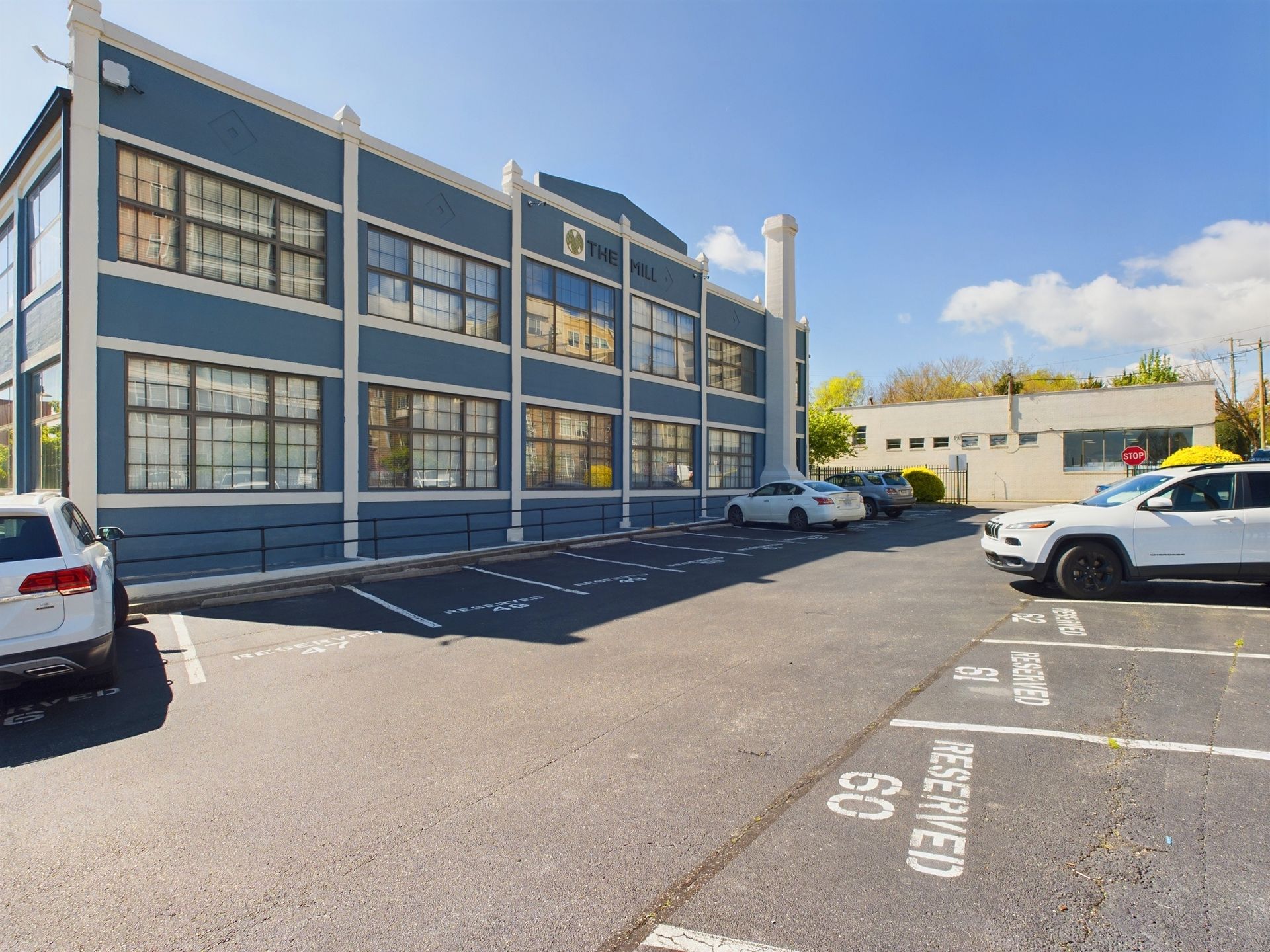 A parking lot with cars parked in front of a large building.