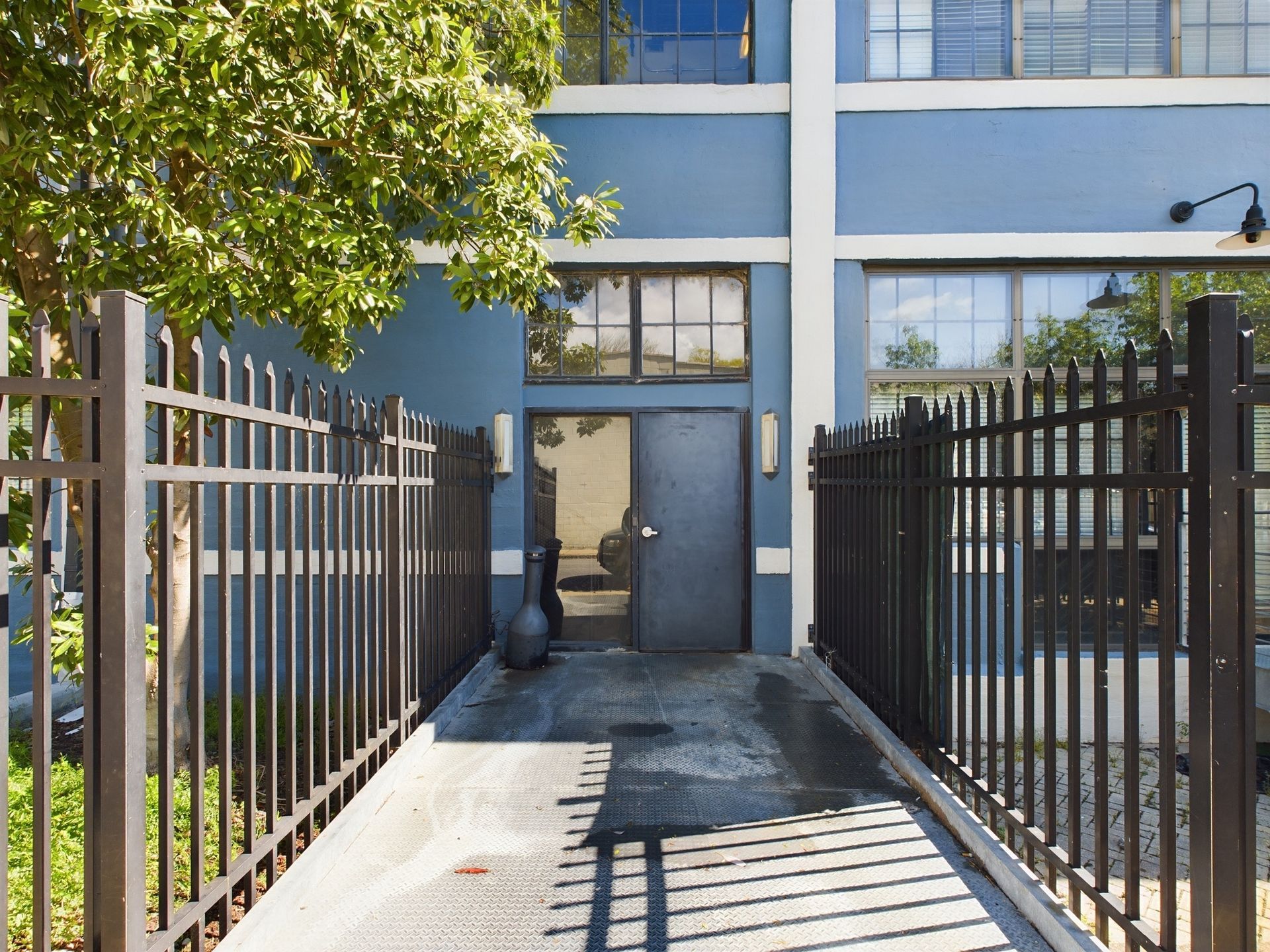 A blue building with a black fence around it