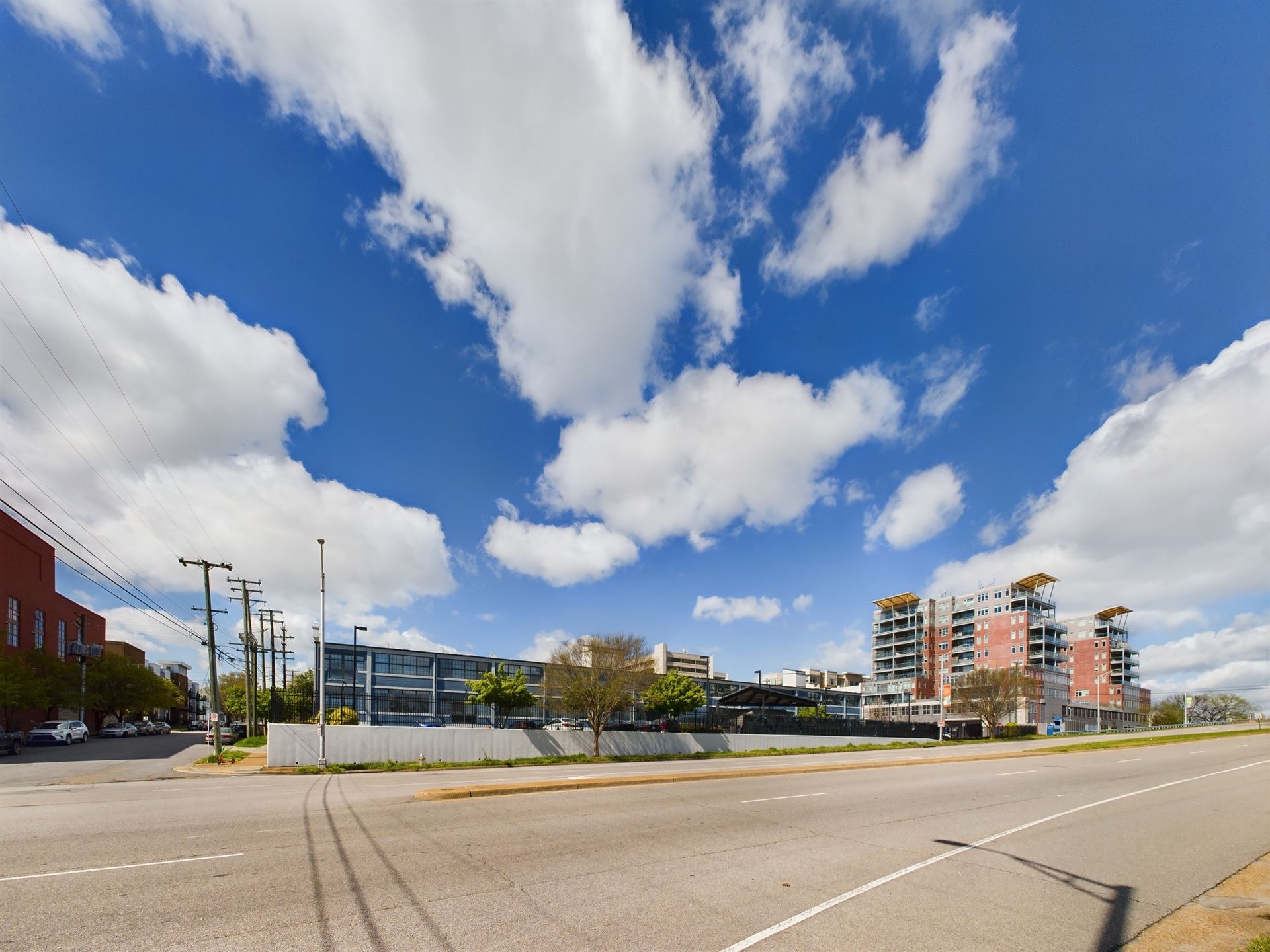 A city street with a blue sky and clouds in the background