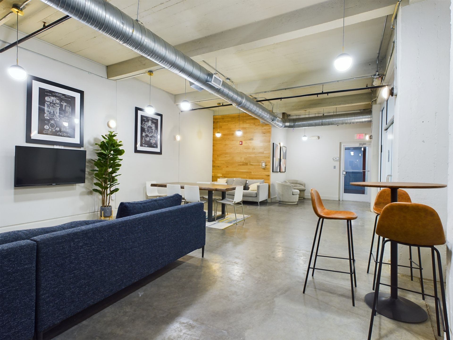A living room with a blue couch , tables and chairs.