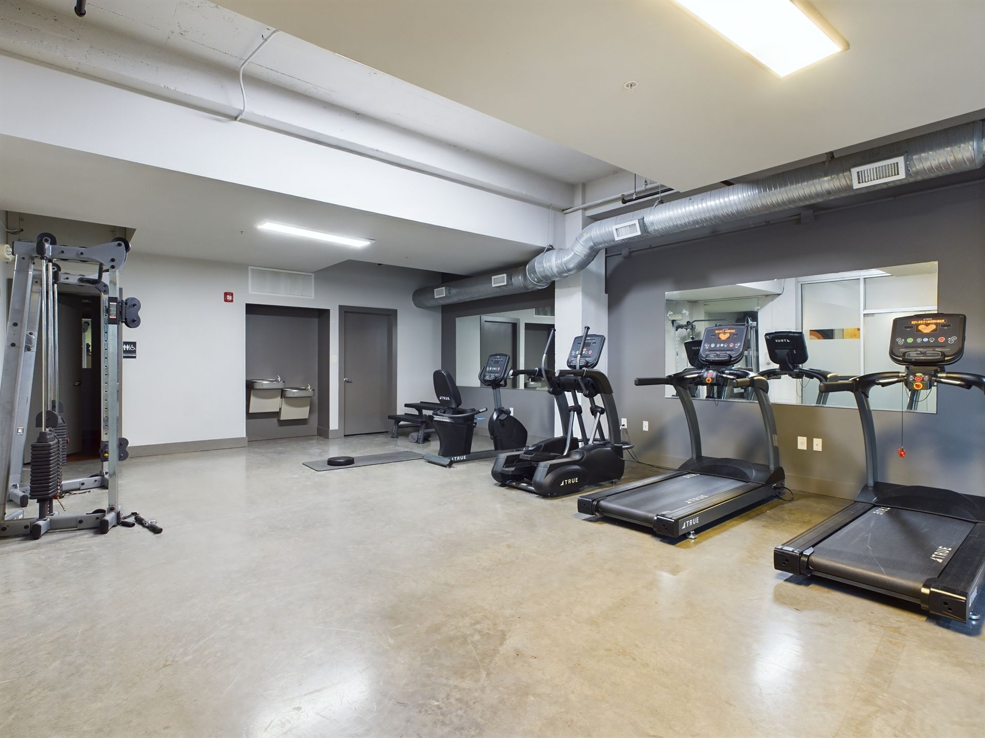 A gym with treadmills , exercise bikes , and a mirror.
