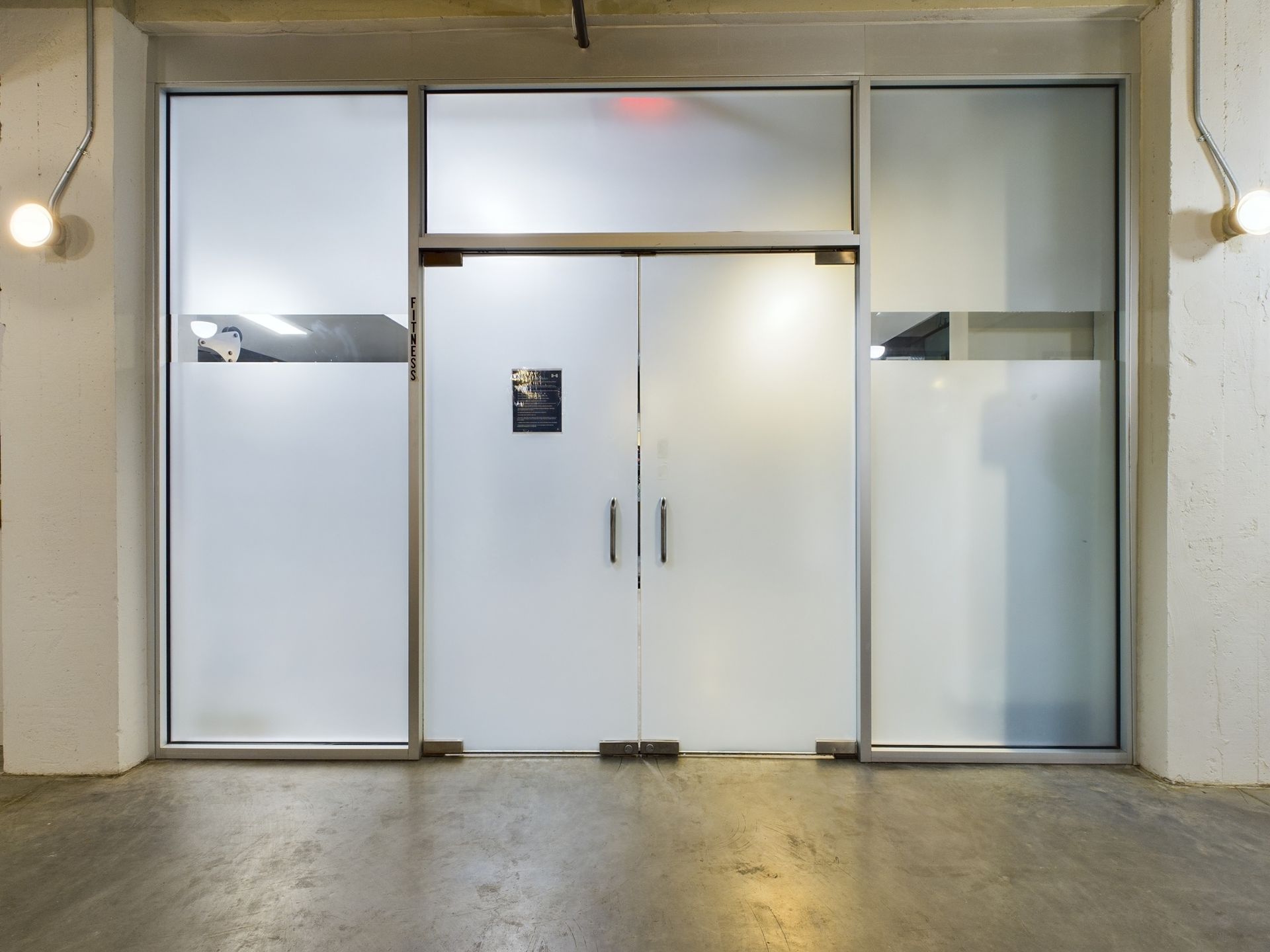 A room with a glass door and a concrete floor