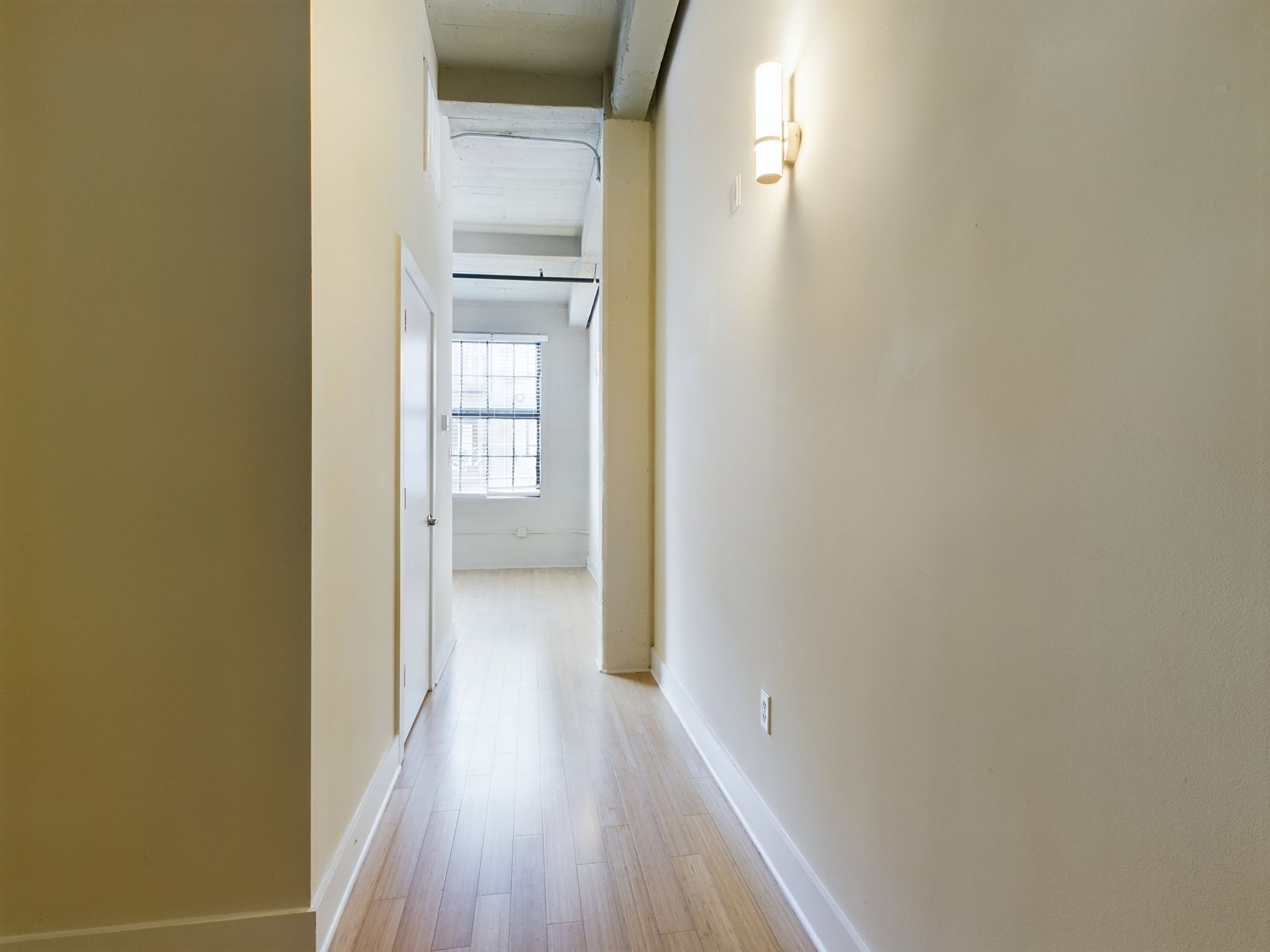 An empty hallway with hardwood floors and white walls