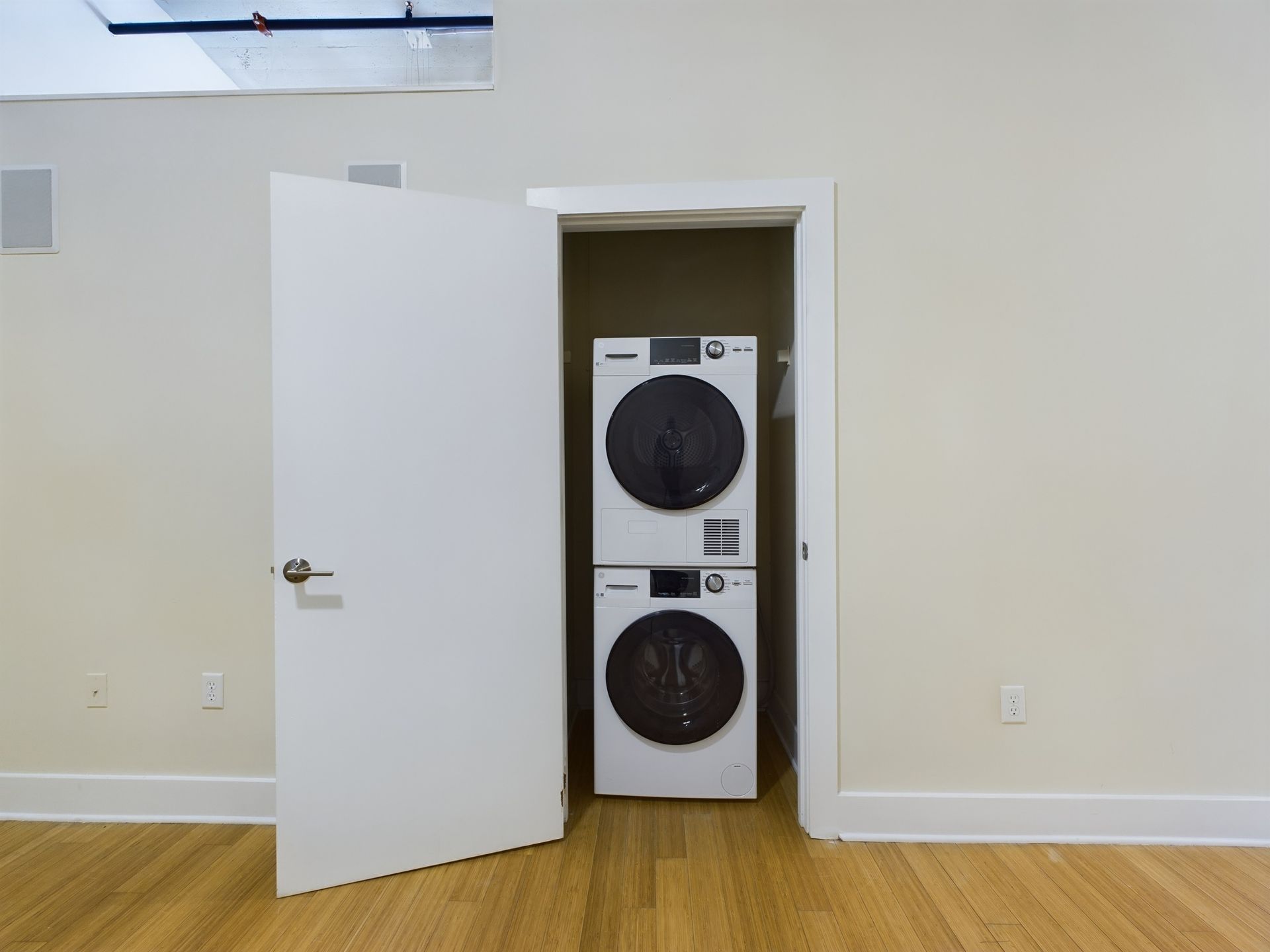 A washer and dryer are stacked on top of each other in a closet