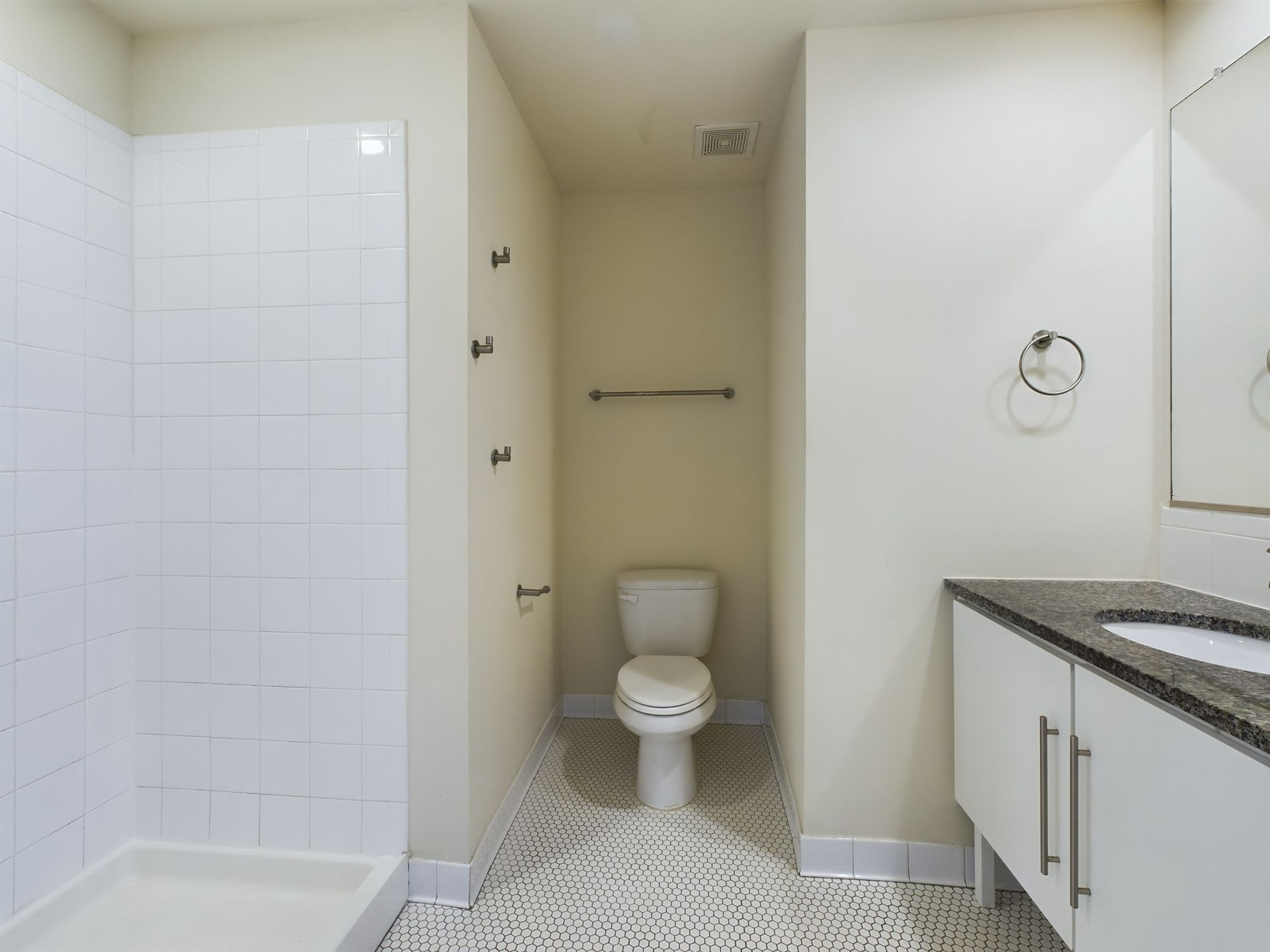 A bathroom with a toilet , sink and shower.