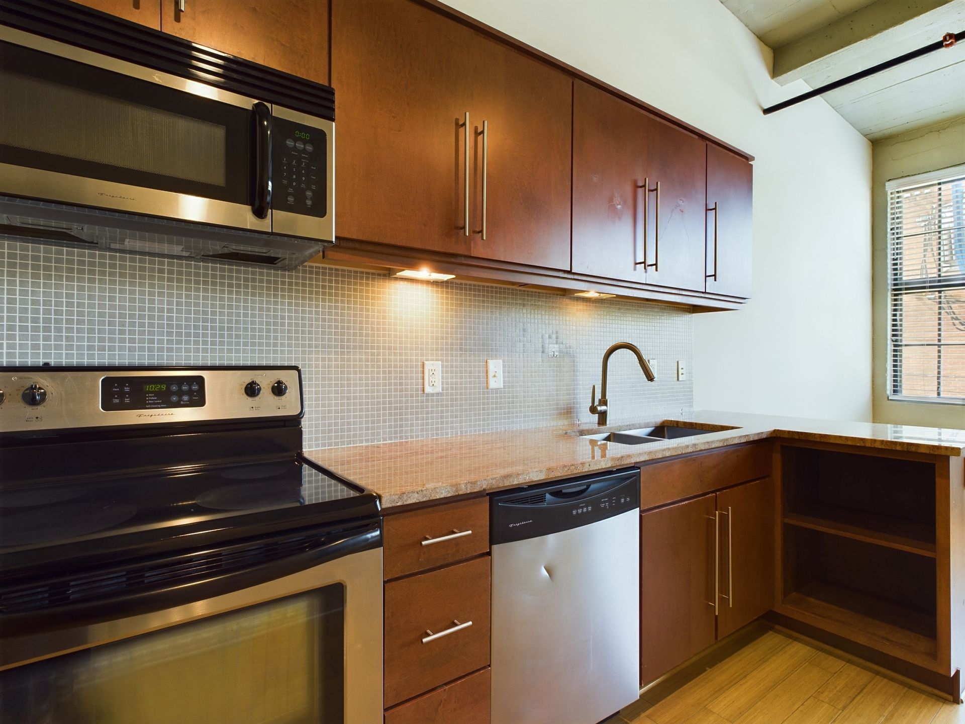 A kitchen with stainless steel appliances and wooden cabinets