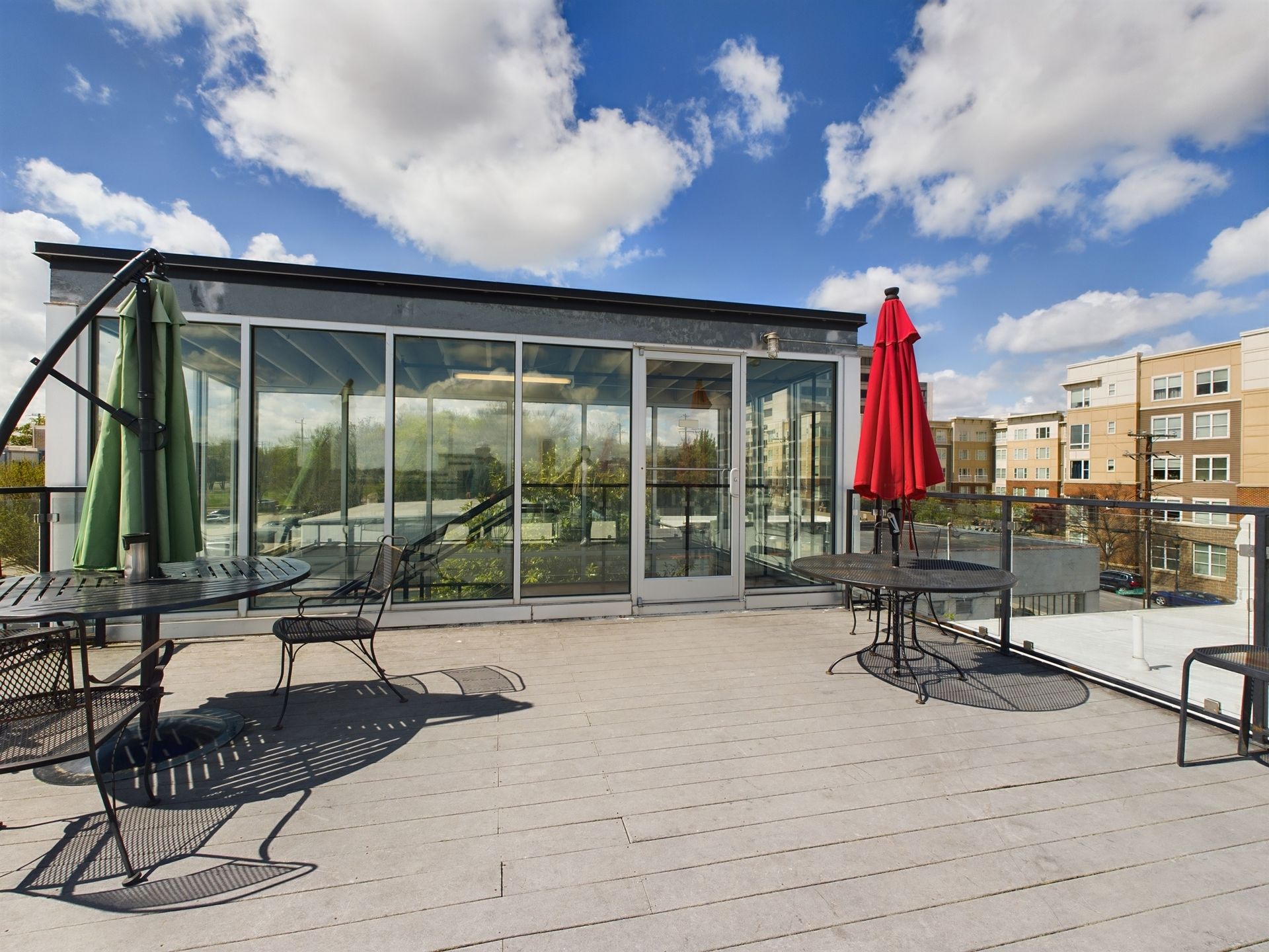 A rooftop deck with tables and chairs and umbrellas