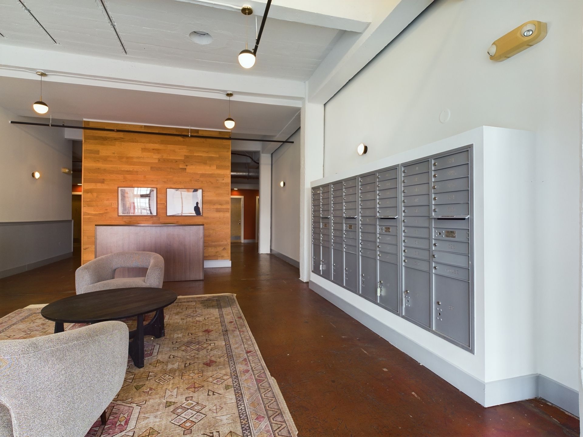 A living room with a row of mailboxes on the wall